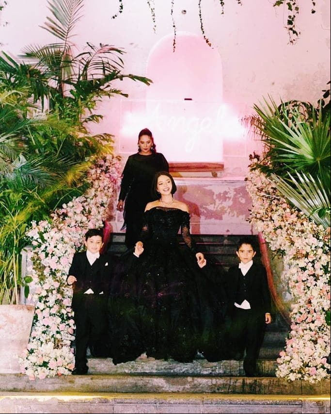Ángela mantuvo el corte bob para su fiesta de XV años, donde utilizó tres vestidos diferentes, destacando un diseño negro que dejó al descubierto sus hombros.