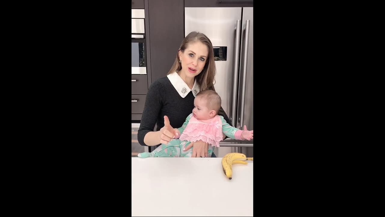 La cocina está forrada por muebles de color caoba oscuro y electrodomésticos de acero inoxidable, los cuales están empotrados.