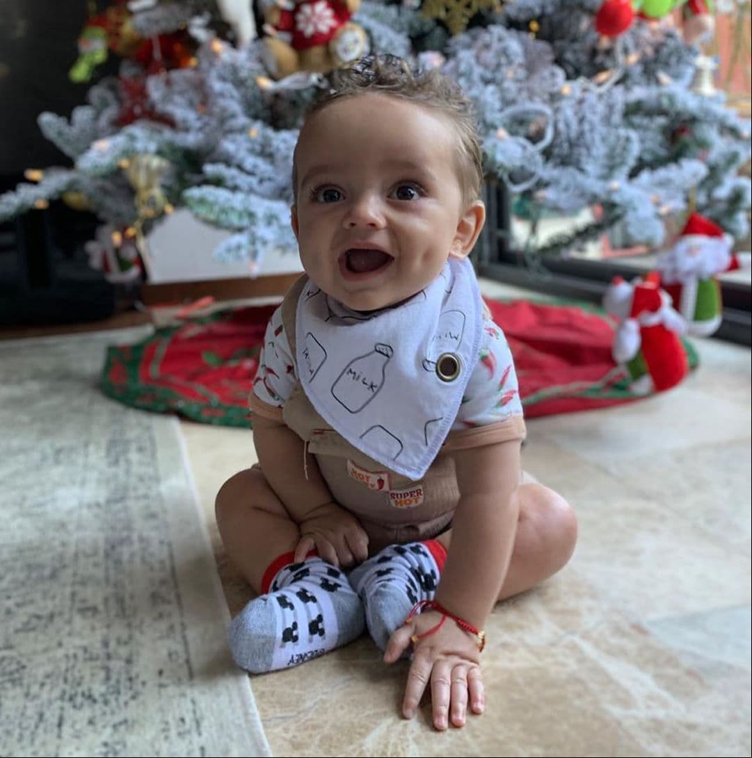 Una de las imágenes por las que se volvió tendencia fue una postal navideña, en la que aparece sonriendo frente al árbol de navidad y la cual compartieron sus famosos padres.
