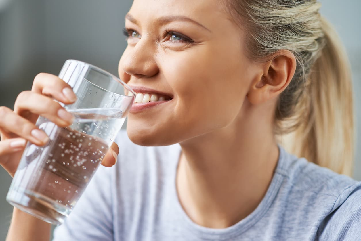Beautiful young woman drinking water