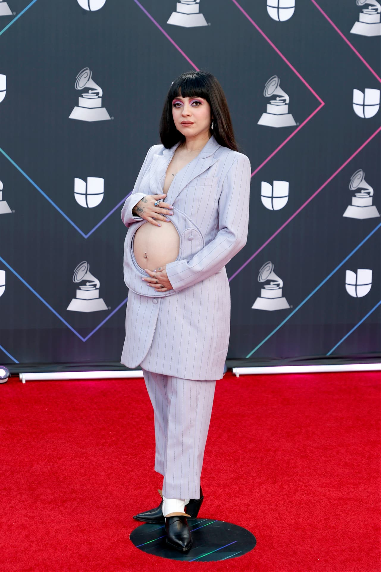 Indiscutiblemente, uno de los favoritos. La cantante chilena, Mon Laferte, desfiló ante las cámaras con un simple y a la vez innovador outfit: un suit lila con ligeras rayas verticales y una apertura justo en el vientre en la que presumió su panza de 6 meses de embarazo. Gloria Trevi, una de los muchísimos asistentes que se maravilló con su look, afirmó en cámaras que: "Mon inspira a muchas mujeres que somos madres y trabajamos".