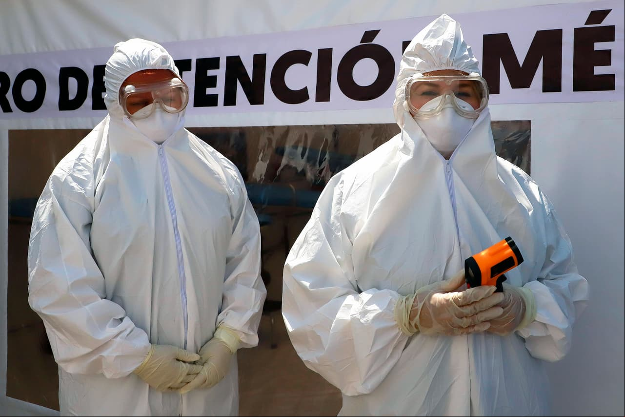 Médicos voluntarios vestidos con un traje, máscara, guantes y gafas protectoras en una carpa instalada para evaluar a personas por Covid-19 en Monterrey.