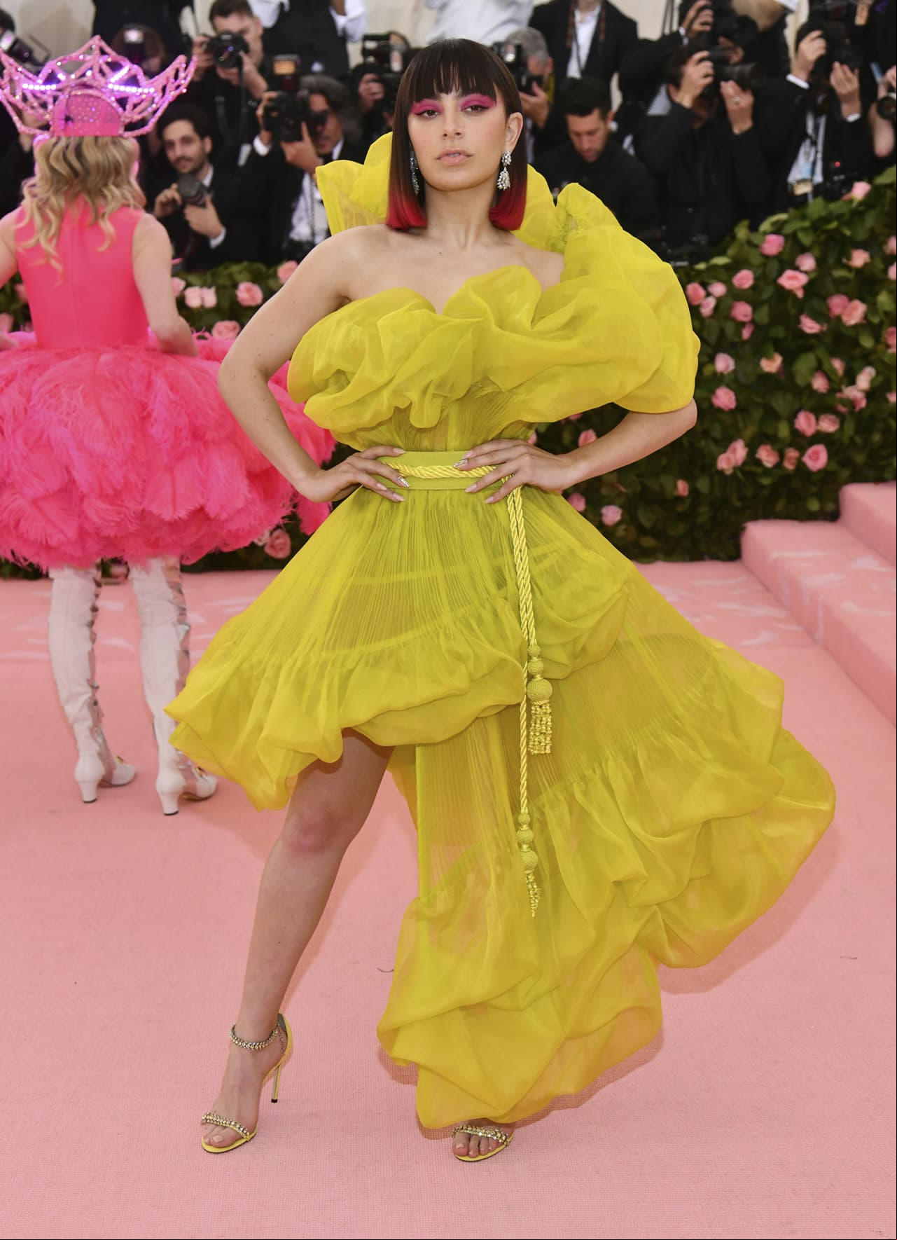 Charli XCX llegó al evento con un vestido asimetrico amarillo con transparencias.