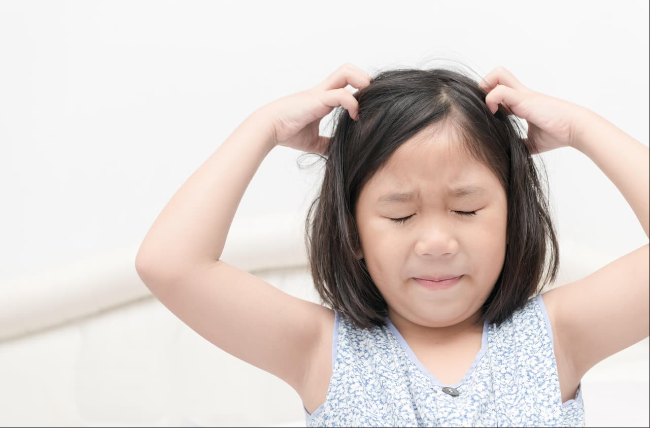 kid with freckles scratching his hair for head lice or allergies, Health care concept