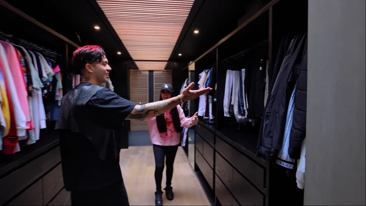 Este clóset tiene anaqueles en color negro, en el que los youtubers tienen toda clase de prendas y además dicha zona da  al baño prinial de la habitación principal.
