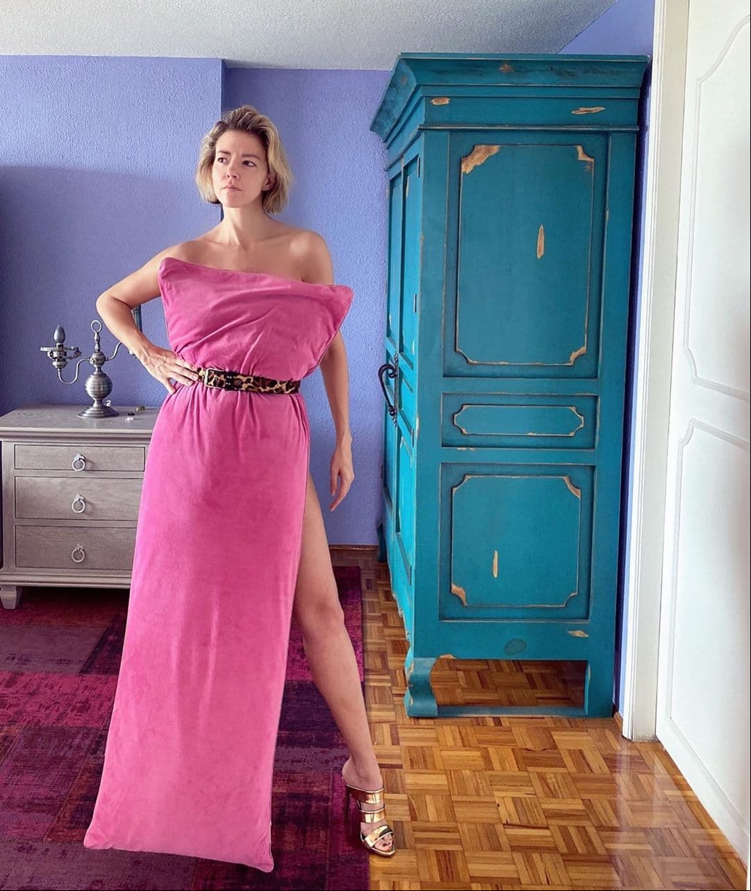 El cuarto tiene pisos que simulan madera y cuenta con un tapete de distintas tonalidades de rosa y morado; además, de un clóset color azul rey.