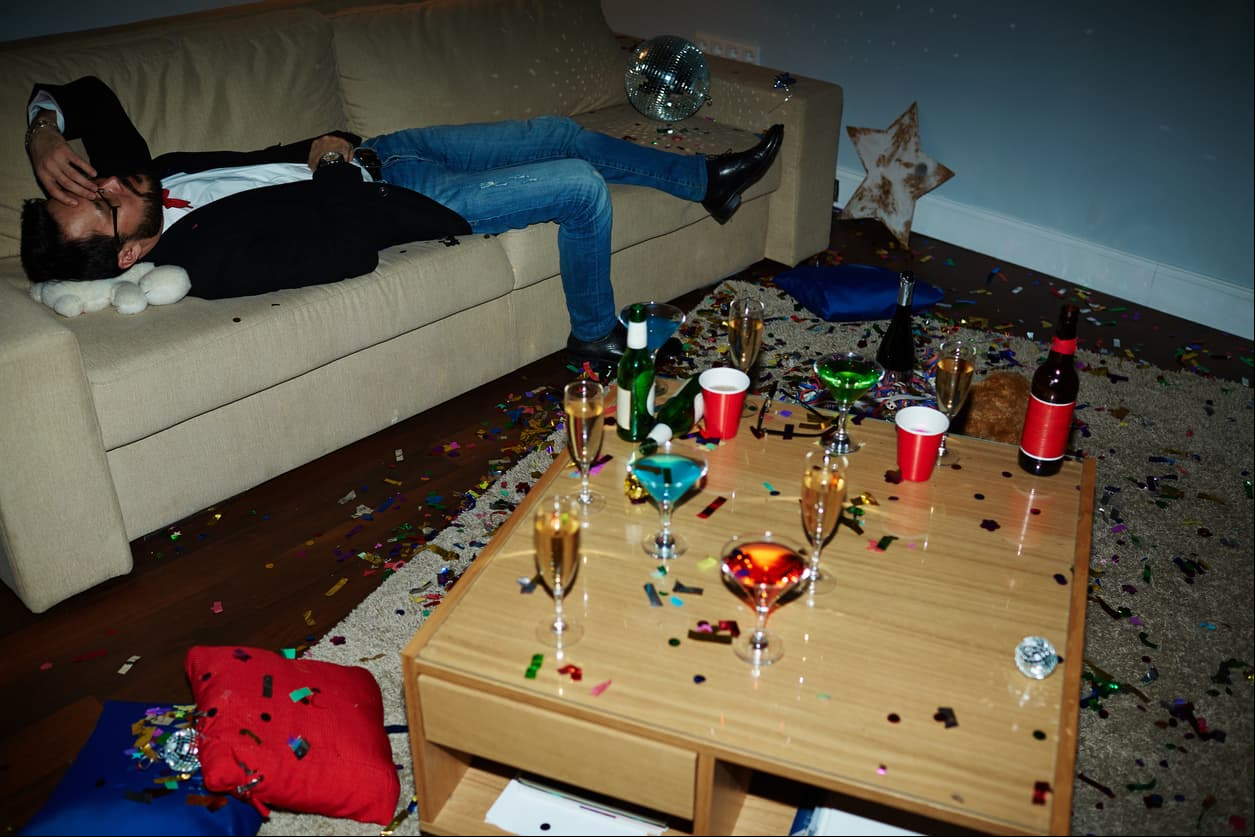 Exhausted man lying on sofa after tiresome party