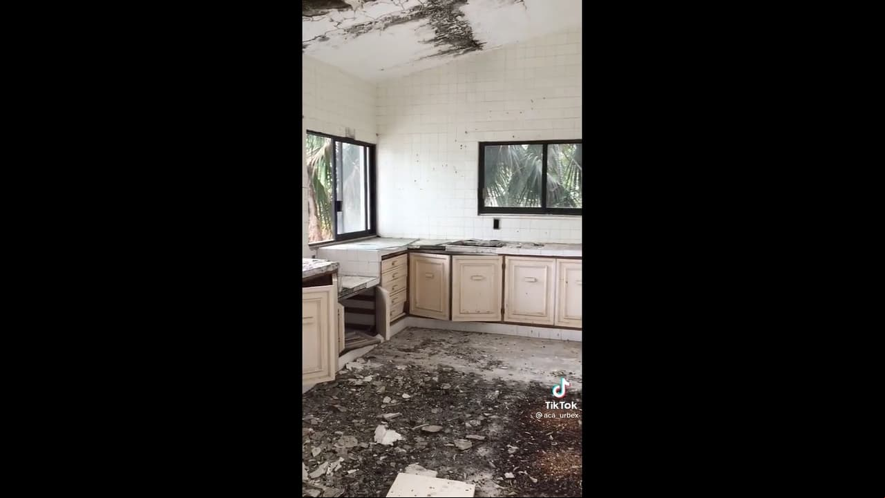La cocina, ubicada justo al lado de la entrada, está casi destruida en su totalidad y cuenta con innumerables gabinetes todos en color marfil.