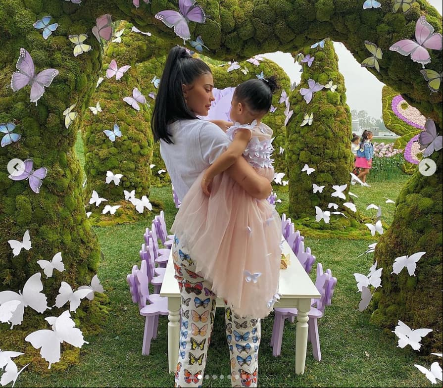 La hermana menor del clan Kardashian-Jenner optó por ropa cómoda al usar un pantalón con diversos diseños de mariposas de Versace, además de una camisa blanca.